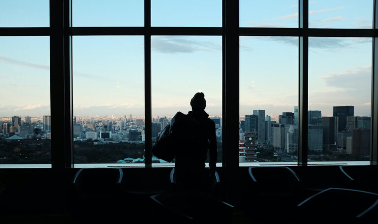 Woman Looking out Windows of FBO Airport